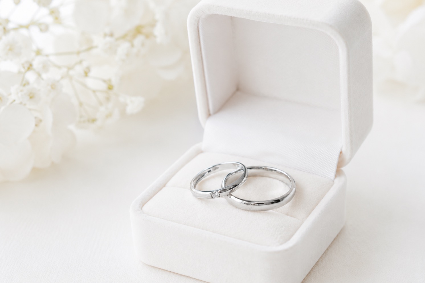 結婚指輪と婚約指輪をつけたカップルの手